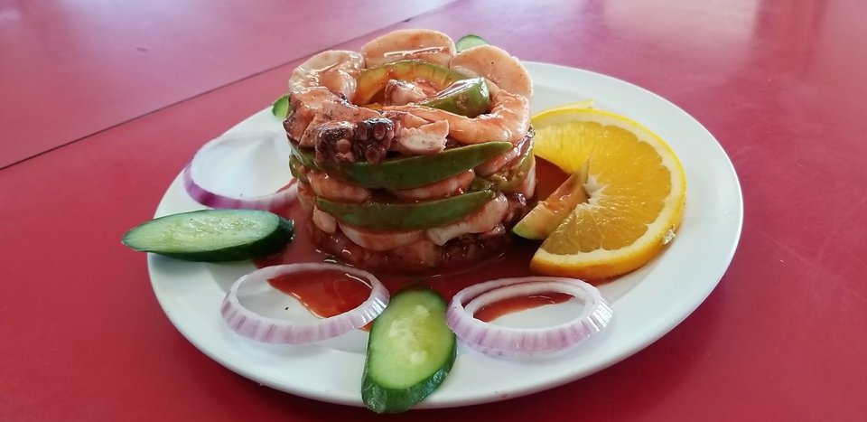 Fresh seafood plates beside lime wedges.