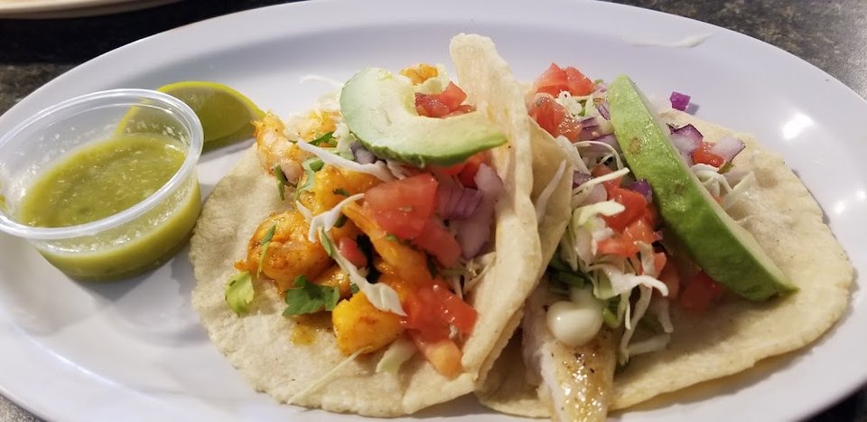 Printed menu with tacos and seafood.
